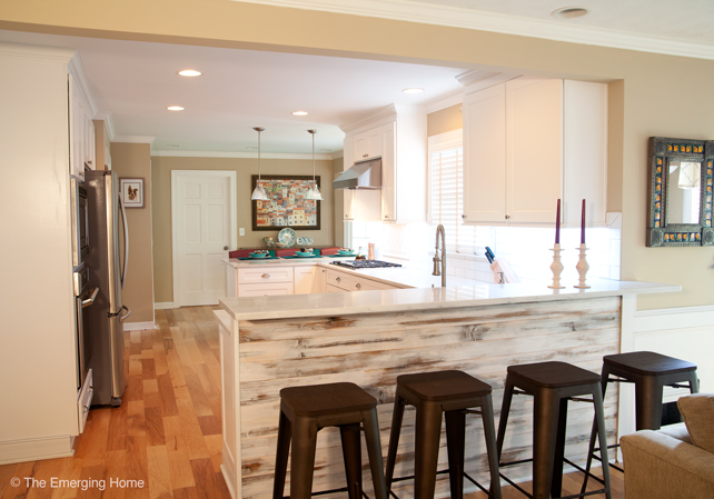 View from the family room into the kitchen shows the wall removed and a counter bar with tall stools in its place.