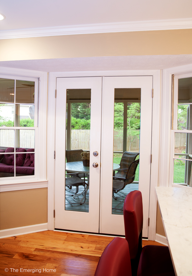 Double French style doors have been installed in place of a solid square window. New doors allow access to seating and eating area on screen porch. 