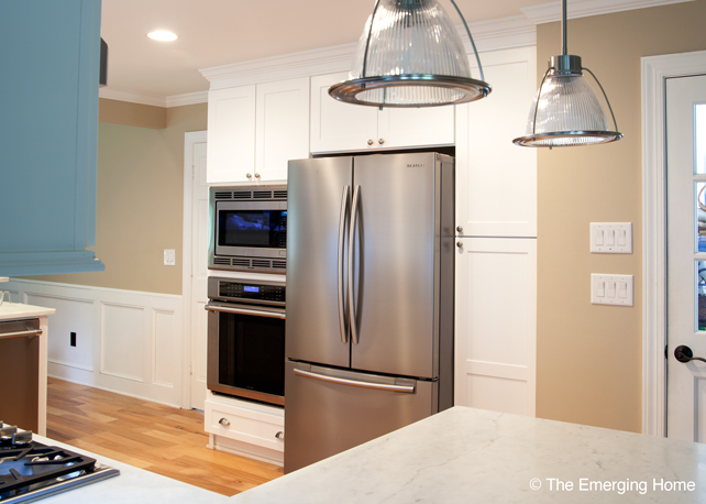 Two door, vertical, pantry cabinet is installed beside refrigerator