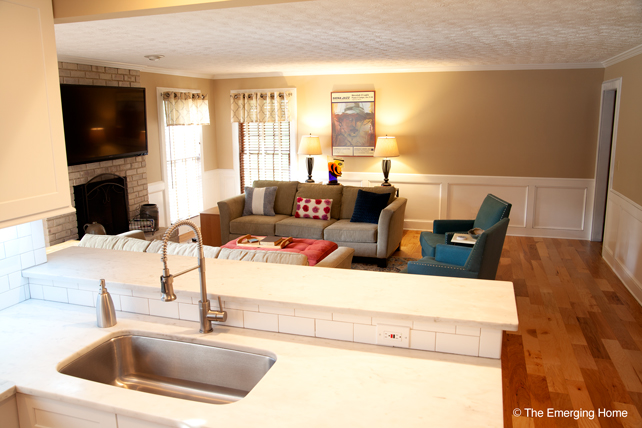 View from marble countertops and kitchen sink area looking into family room and entertainment center.