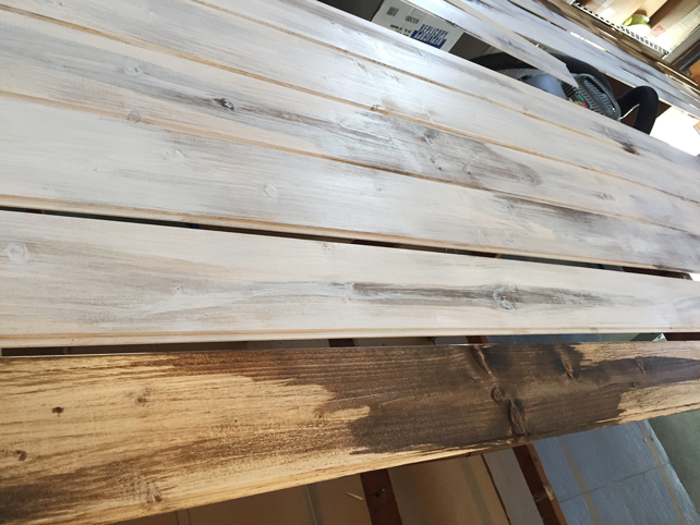 Closeup of planks with white paint over dark stain