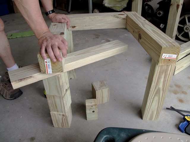 connecting the top frame of the rain barrel stand to the legs with screws