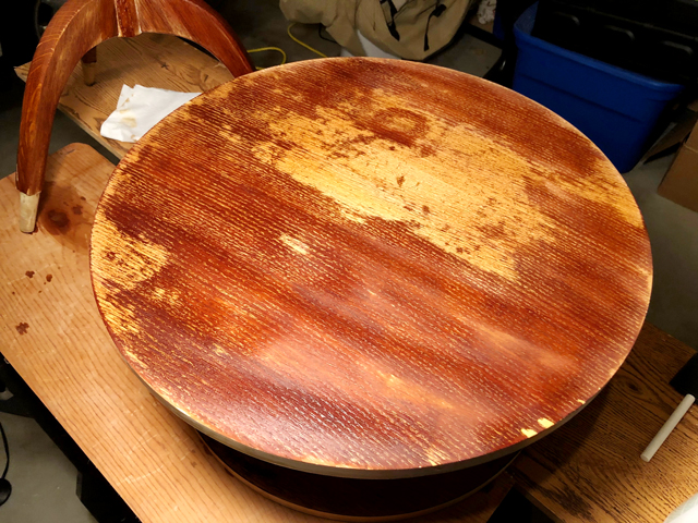 Bleach at work on tabletop resulting in dark and light uneven coloration 