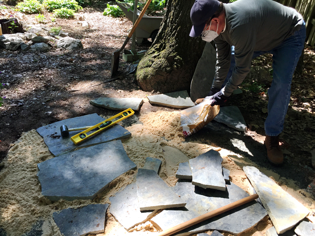 laying out the gray flagstone on the leveling sand 