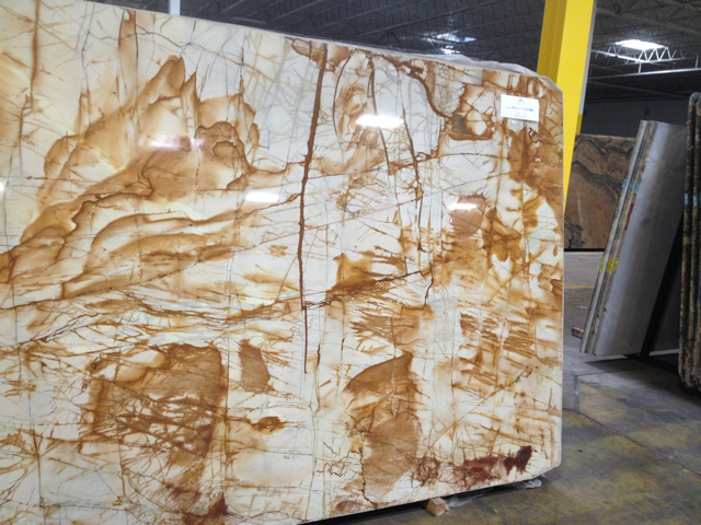 Large slab of stone with abstract brown patches on white marble background