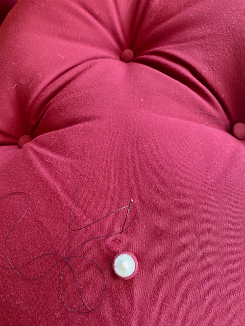 threaded needle with button on cushion