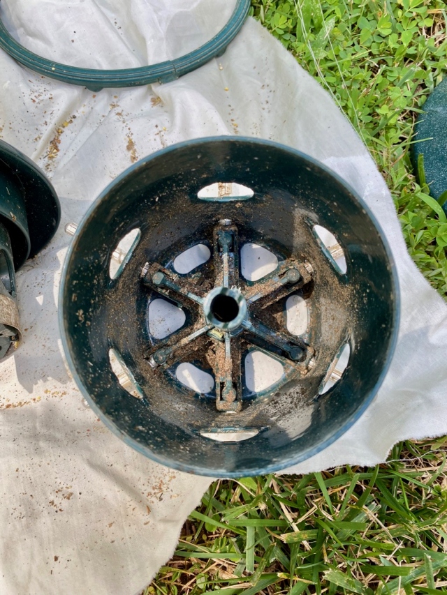 green, dirty, metal piece of bird feeder 