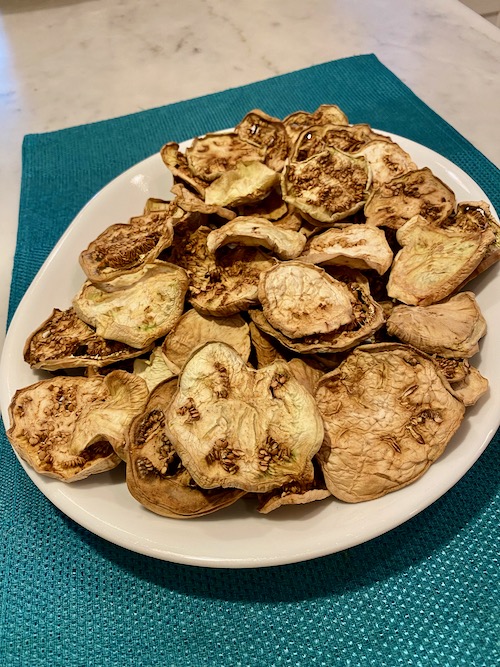 brown, thin, wrinkled, dehydrated eggplant slices after coming out of dehydrator