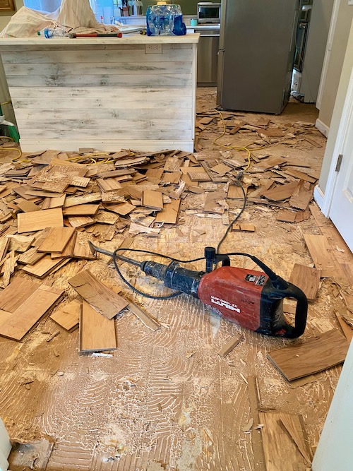 small pieces of wood flooring lie in piles after being pried from floor